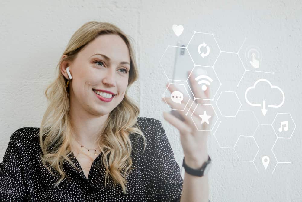 une fmme qui tape sur un clavier virtuel devant elle, avec un mir blanc devant , community management 2026