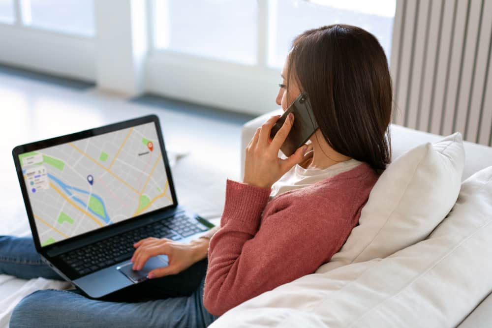 une femme qui parle au téléphone et qui tient un ordinateur sur  ses genoux, SEO local 
