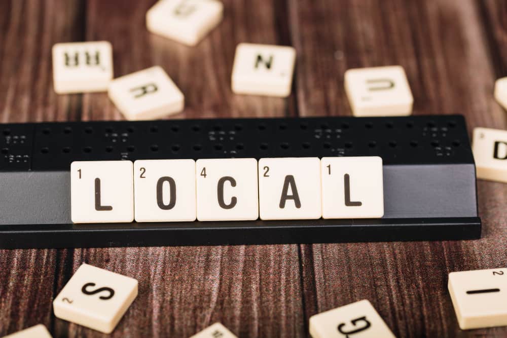 un jeu de puzzle avec le mot LOCAL sur une table en bois sombre, SEO local