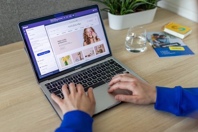 des mains d'hommes qui tapent sur le clavier d'un ordinateur avec uun site ecommerce affiché, création site web PME