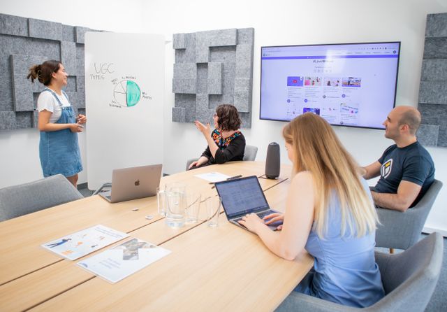 l'équipe d'uen agence de communication toulouse assis autour d'un bureau devant un tableu blanc avec des post it