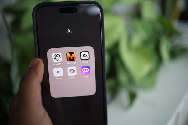 une main qui tient un téléphone avec des IA sur l'écran, agence ia