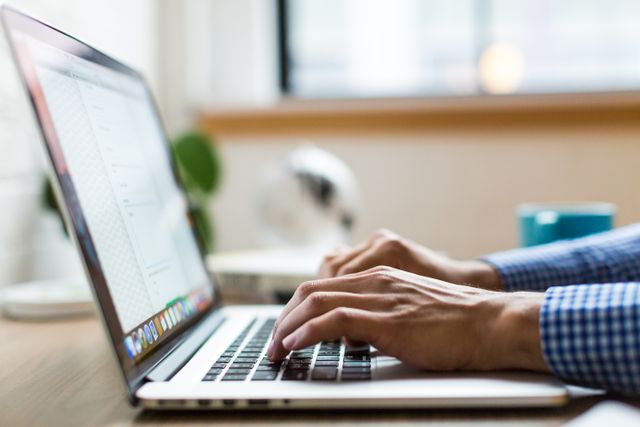 des mains qui tapent sur le clavier d'un ordinateur portable, agence maintenance wordpress